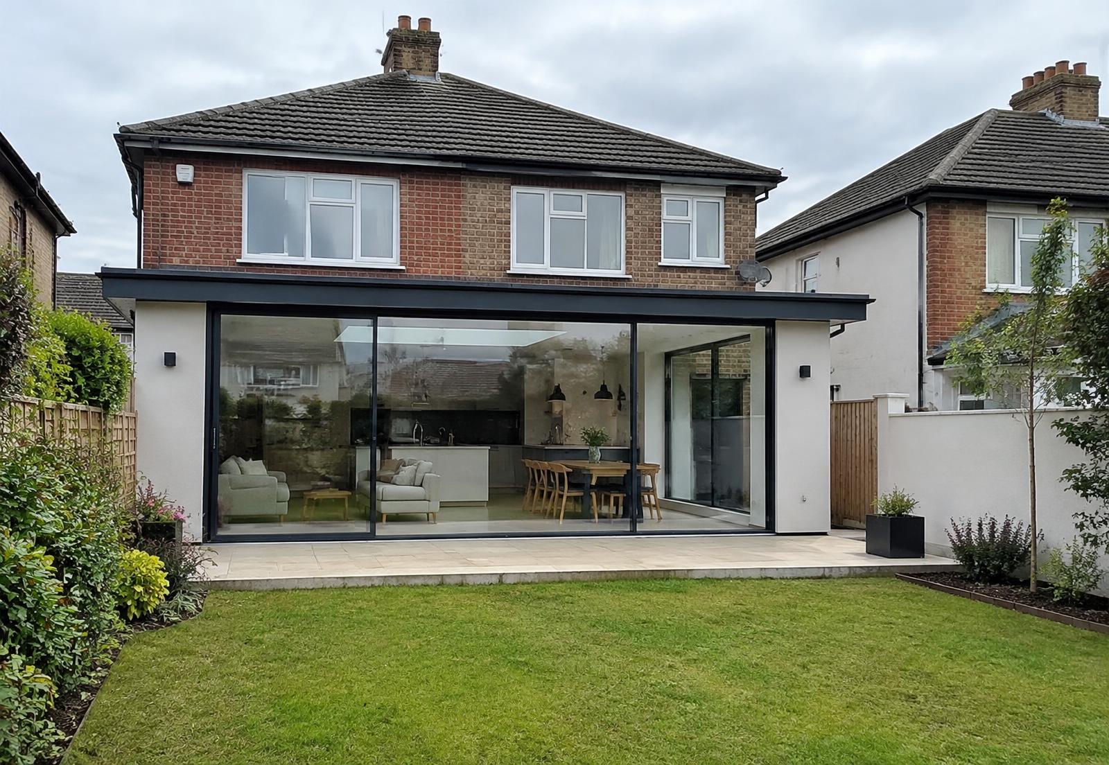 A rendered rear extension with full-height glazing opening onto a garden